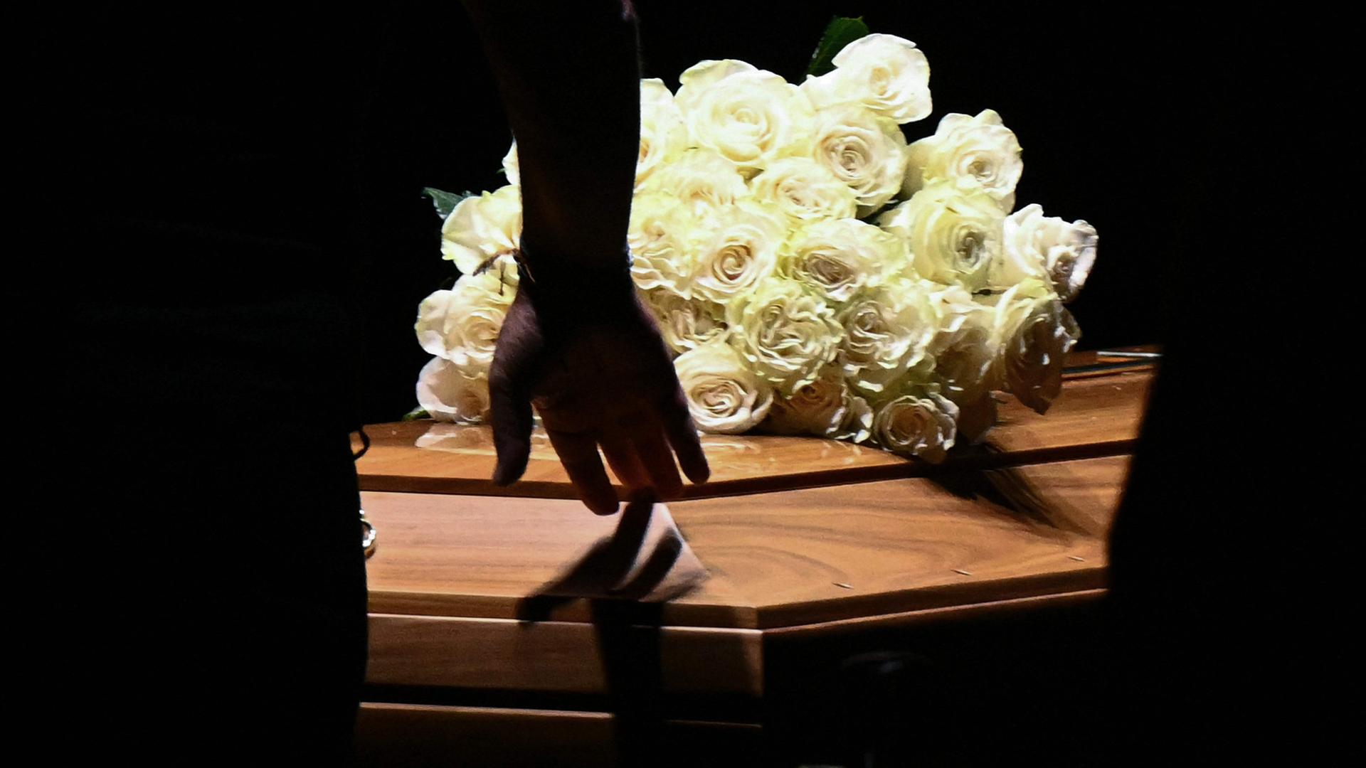 Ein Mann berührt am 06.09.2025 den Sarg von dem verstorbenen Modedesigner Giorgio Armani in Mailand.