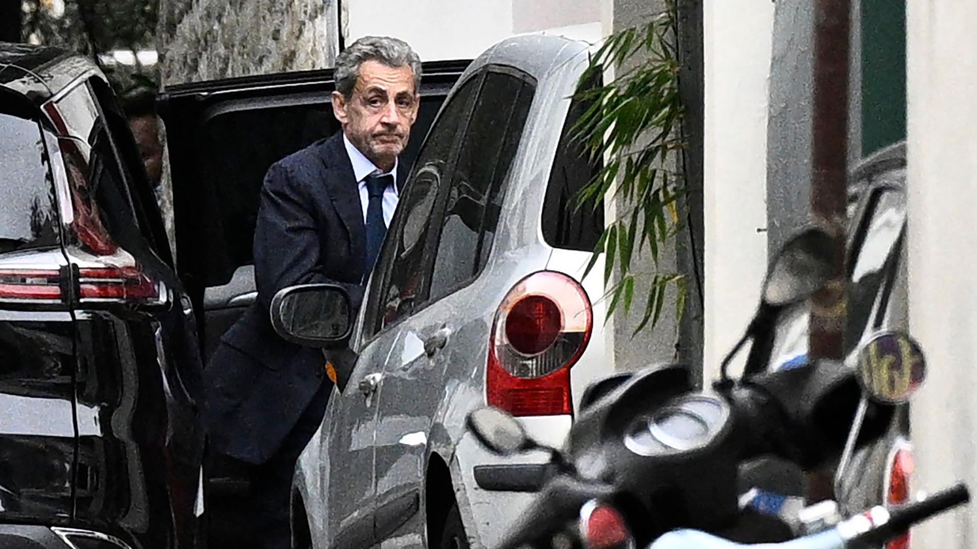 Frankreichs ehemaliger Präsident Nicolas Sarkozy steigt aus einem Fahrzeug bei der Rückkehr zu seinem Wohnhaus, nachdem er mit Staatsanwälten über den Antritt seiner Haftstrafe gesprochen hat. 