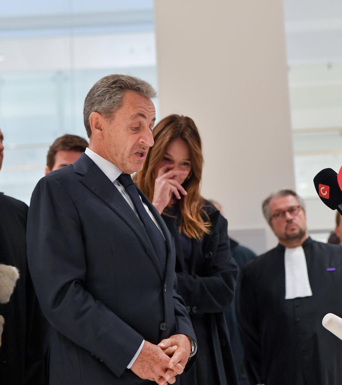 Den verurteilten ehemaligen Präsidenten Sarkozy im Gericht in Paris. Um ihn herum sind viele Menschen von der Presse