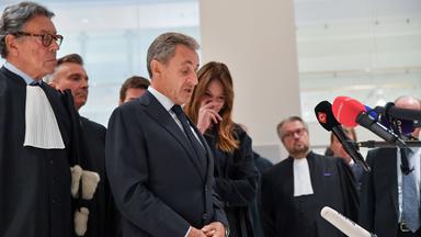 Den verurteilten ehemaligen Präsidenten Sarkozy im Gericht in Paris. Um ihn herum sind viele Menschen von der Presse