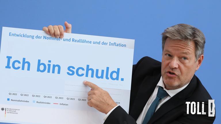 Robert Habeck zeigt mit dem Finger auf ein Schild, darauf steht: "Ich bin schuld." 