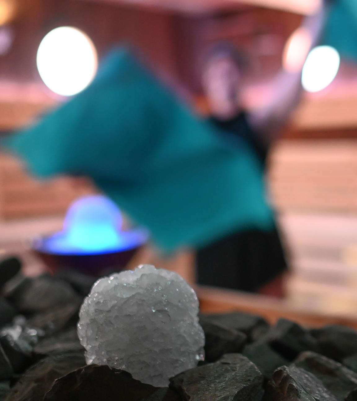  Schneebälle aus Crushed Ice liegen in einer Sauna in Ostfriesland neben einem Sauna-Ofen für einen Aufguss bereit. (Archiv)