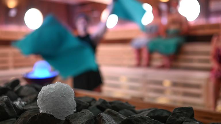  Schneebälle aus Crushed Ice liegen in einer Sauna in Ostfriesland neben einem Sauna-Ofen für einen Aufguss bereit. (Archiv)