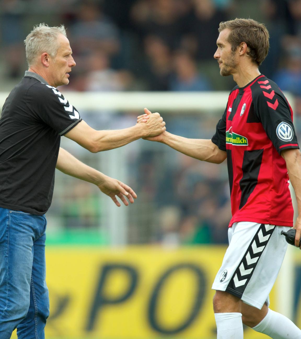 DFB-Pokal am 20. August 2016: SC-Freiburg-Trainer Christian Streich und Spieler Julian Schuster (rechts) schlagen mit der Hand ein.