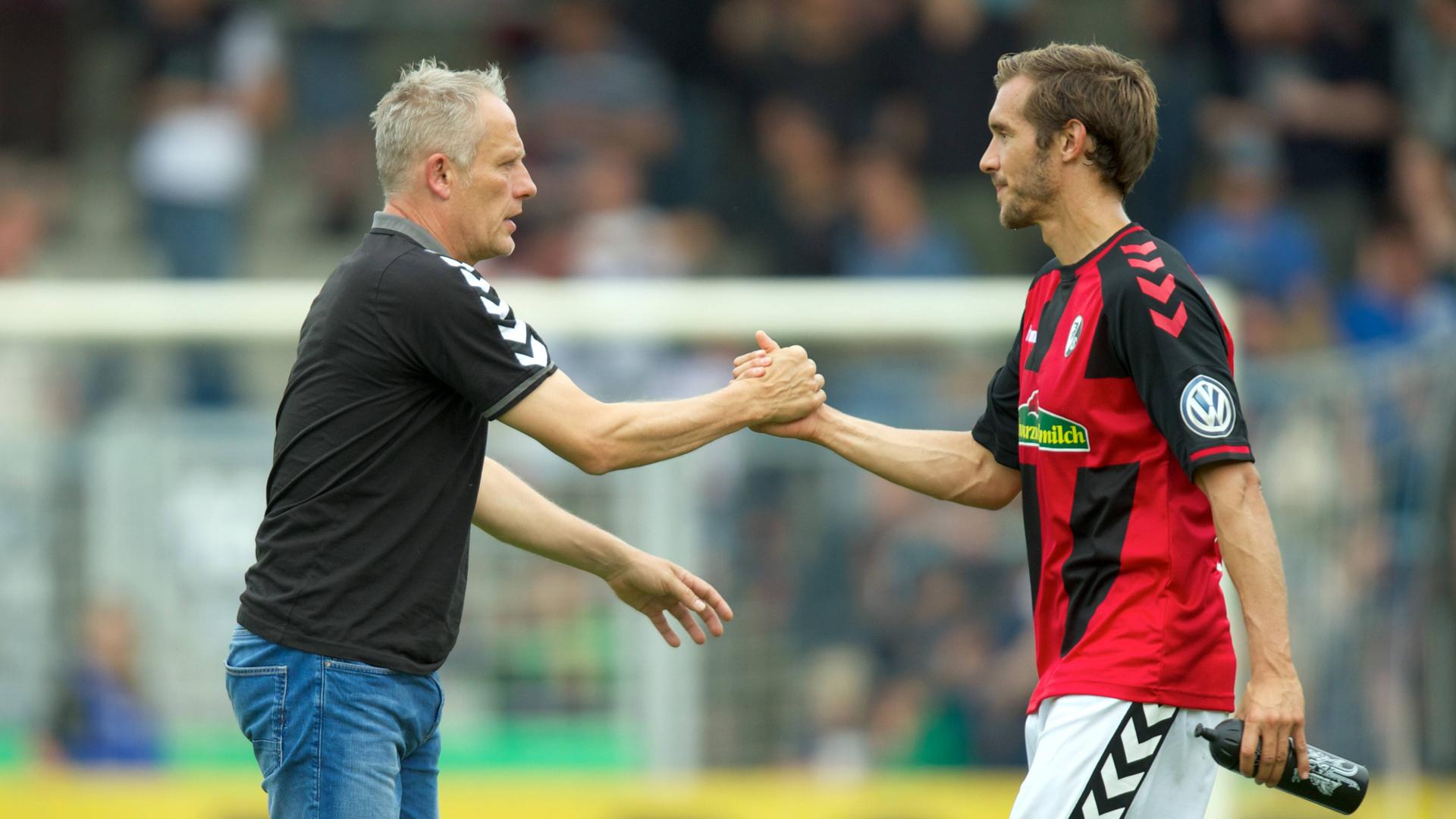 DFB-Pokal am 20. August 2016: SC-Freiburg-Trainer Christian Streich und Spieler Julian Schuster (rechts) schlagen mit der Hand ein.