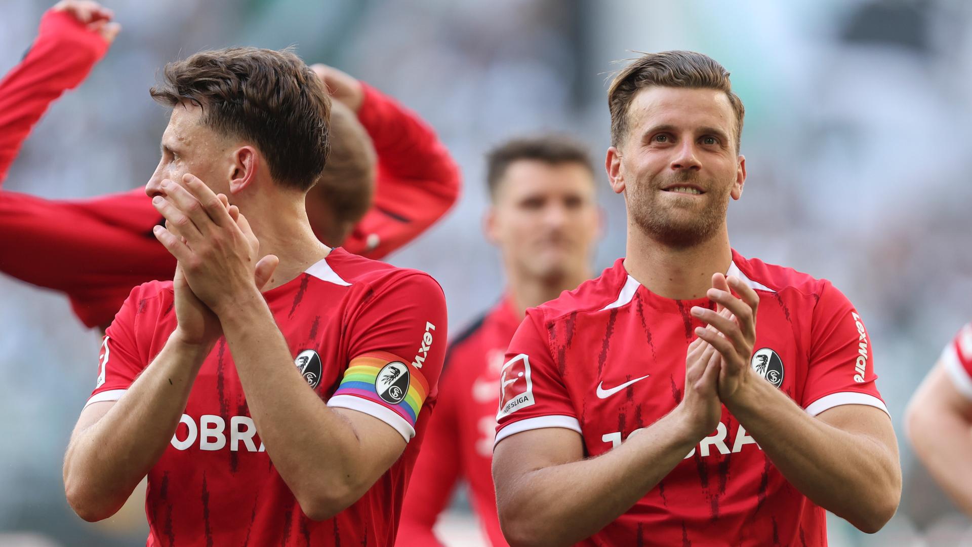 Lucas Höler (rechts) klatschtnach dem Sieg des SC Freiburg gegen Borussia Mönchengladbach in die Hände