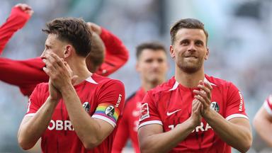 Lucas Höler (rechts) klatschtnach dem Sieg des SC Freiburg gegen Borussia Mönchengladbach in die Hände