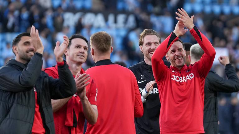 Die Mannschaft vom SC Freiburg feiert den Einzug ins Halbfinale mit den Fans im Gästeblock