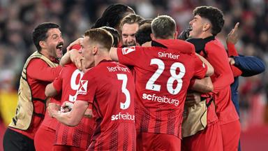 Spieler des SC Freiburg liegen sich in den Armen nach dem Sieg gegen Sporting Braga.