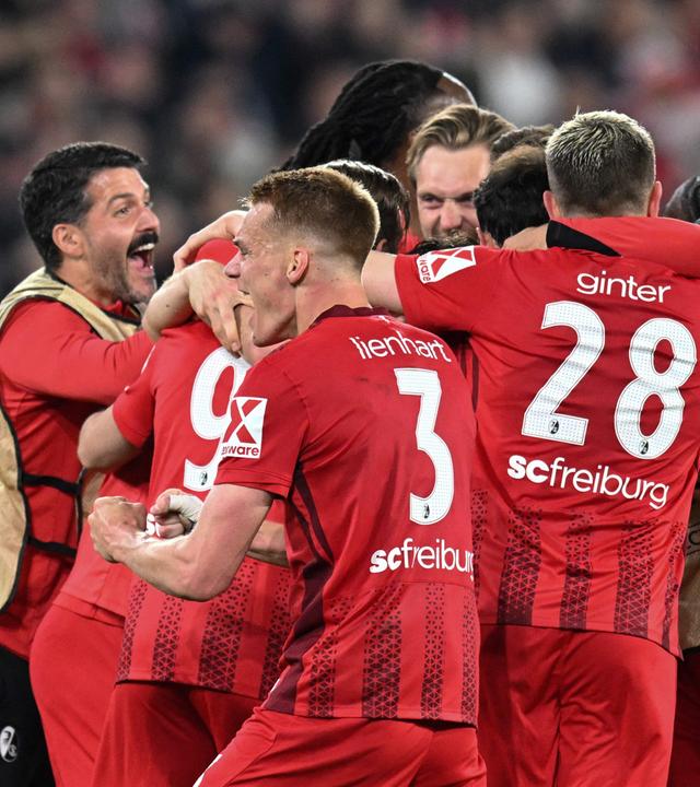 Spieler des SC Freiburg liegen sich in den Armen nach dem Sieg gegen Sporting Braga.
