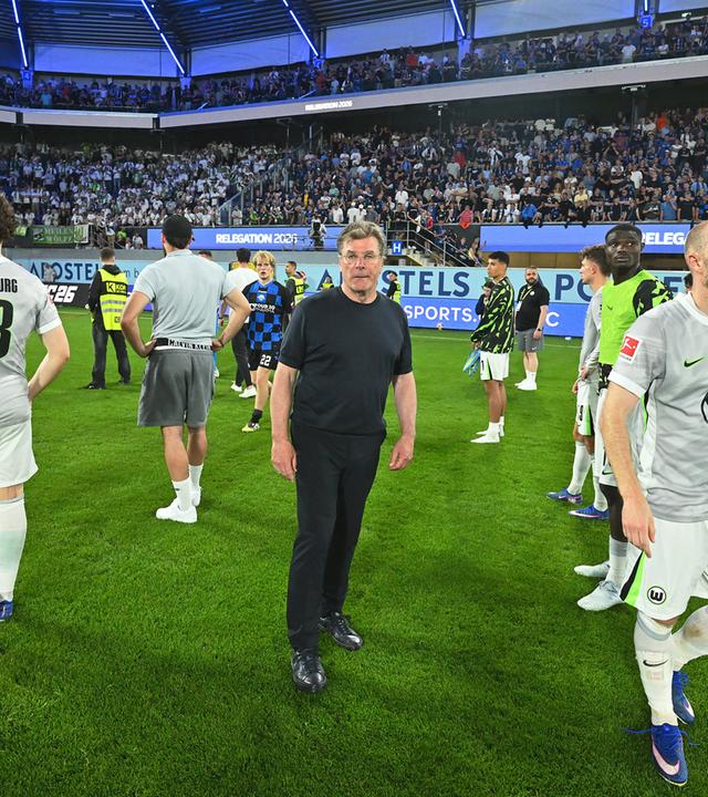 Fußball: SC Paderborn 07 gegen VfL Wolfsburg. Trainer Dieter Hecking (M, VfL Wolfsburg) steht auf dem Spielfeld