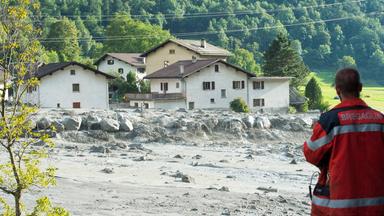 Einsatzkraft blickt auf Schaden nach Erdrutsch am 23.08.2017 in Bondo im Kanton Graubünden, Schweiz.