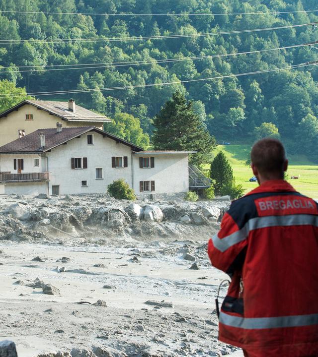 Einsatzkraft blickt auf Schaden nach Erdrutsch am 23.08.2017 in Bondo im Kanton Graubünden, Schweiz.