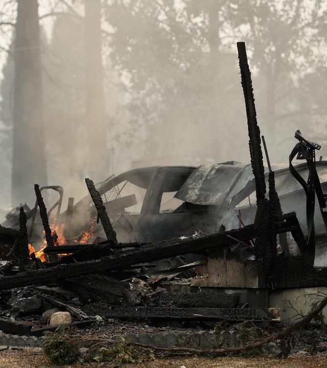Ein Haus das durch einen Waldbrand zerstört wurde, schwelt am 02.08.2026, in Spokane, Washington, USA.