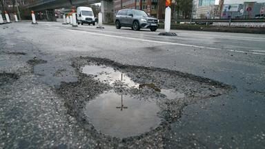 Metergrosse Schlagloecher sind auf einer Straße in Hamburg zu sehen.