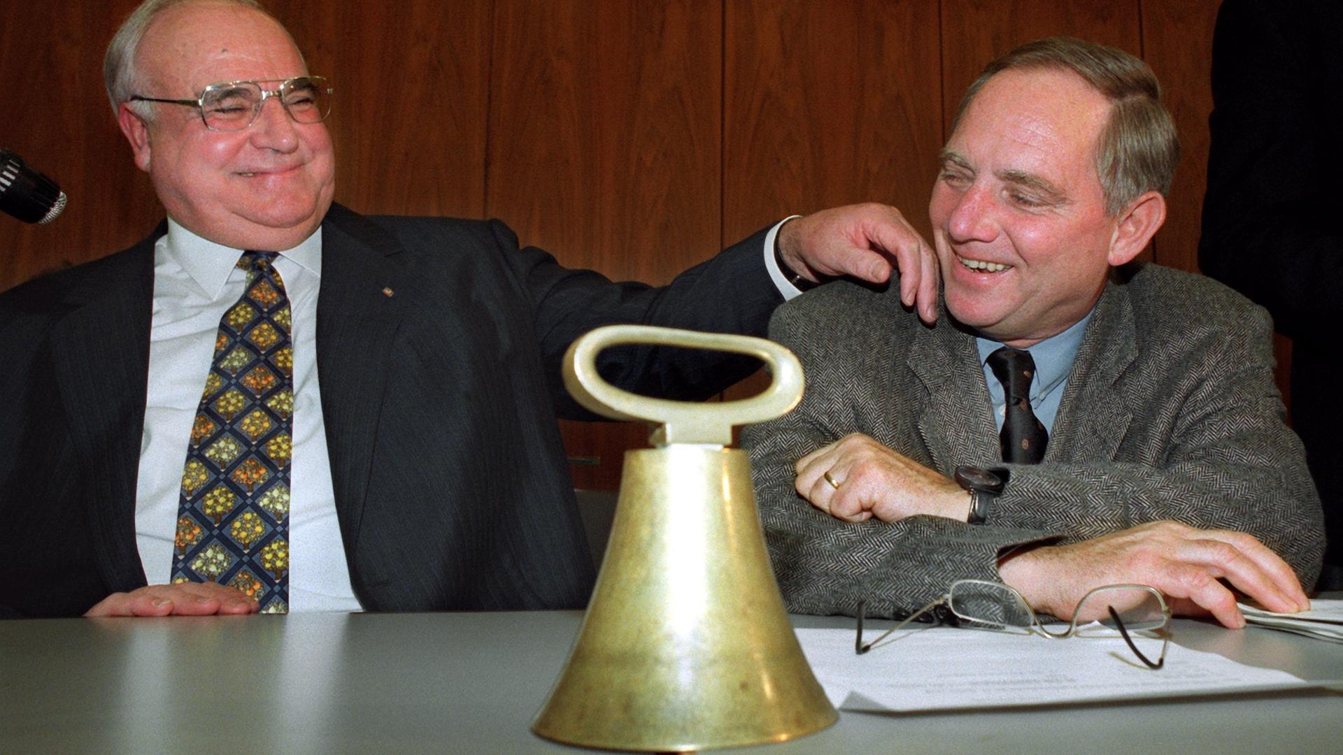 Das Bild zeigt den damaligen Bundeskanzler Helmut Kohl (CDU), wie er Wolfgang Schäuble die Wange tätschelt.