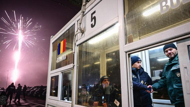 Ein rumänischer und ein bulgarischer Polizeibeamter schütteln sich die Hand an der Grenze der beiden Länder, die jetzt zum Schengen-Raum gehören.