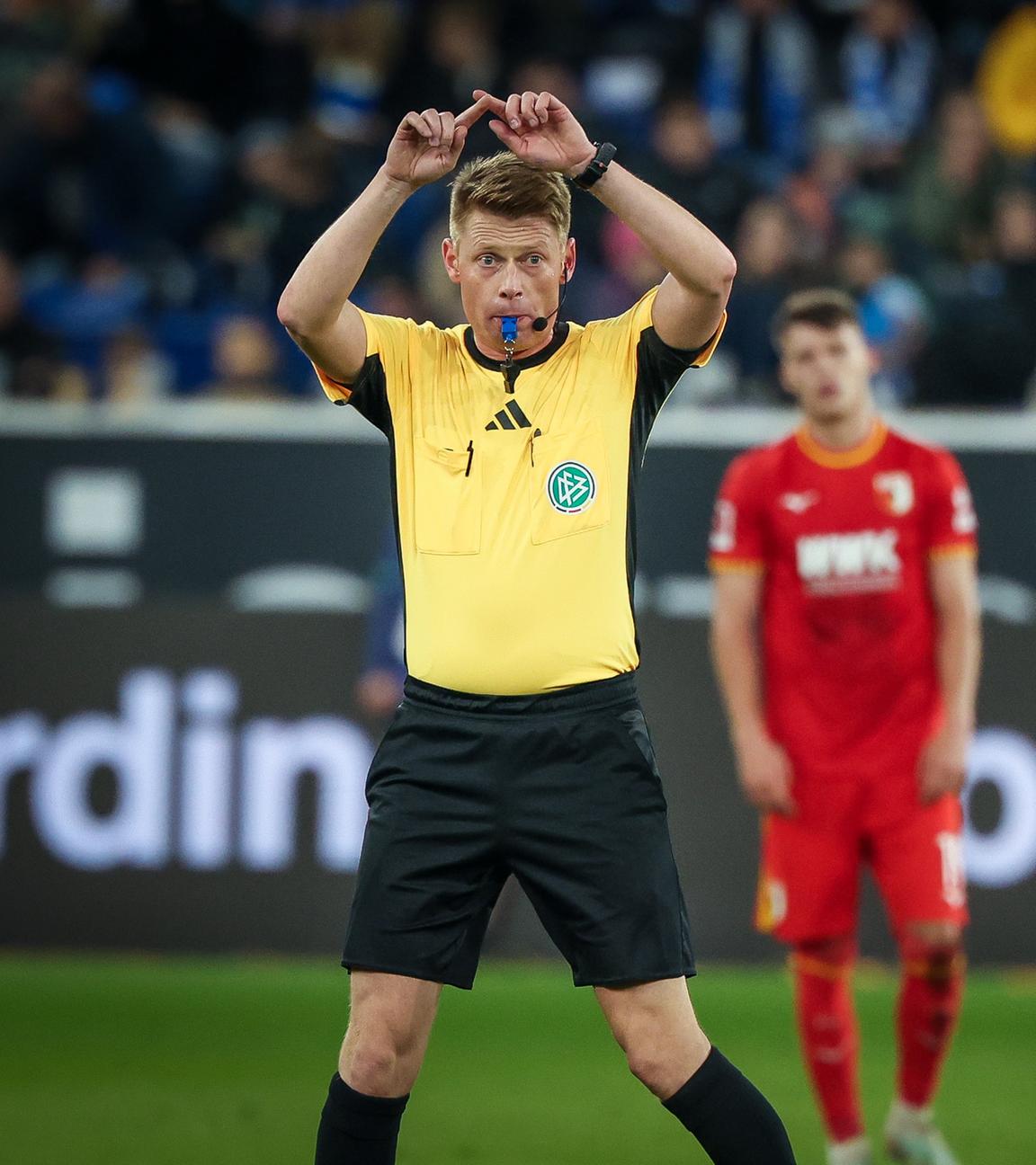 Schiedsrichter Jochen Dingert macht das Handzeichen für den Videobeweis