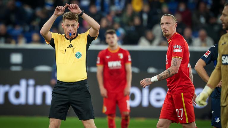 Schiedsrichter Jochen Dingert macht das Handzeichen für den Videobeweis