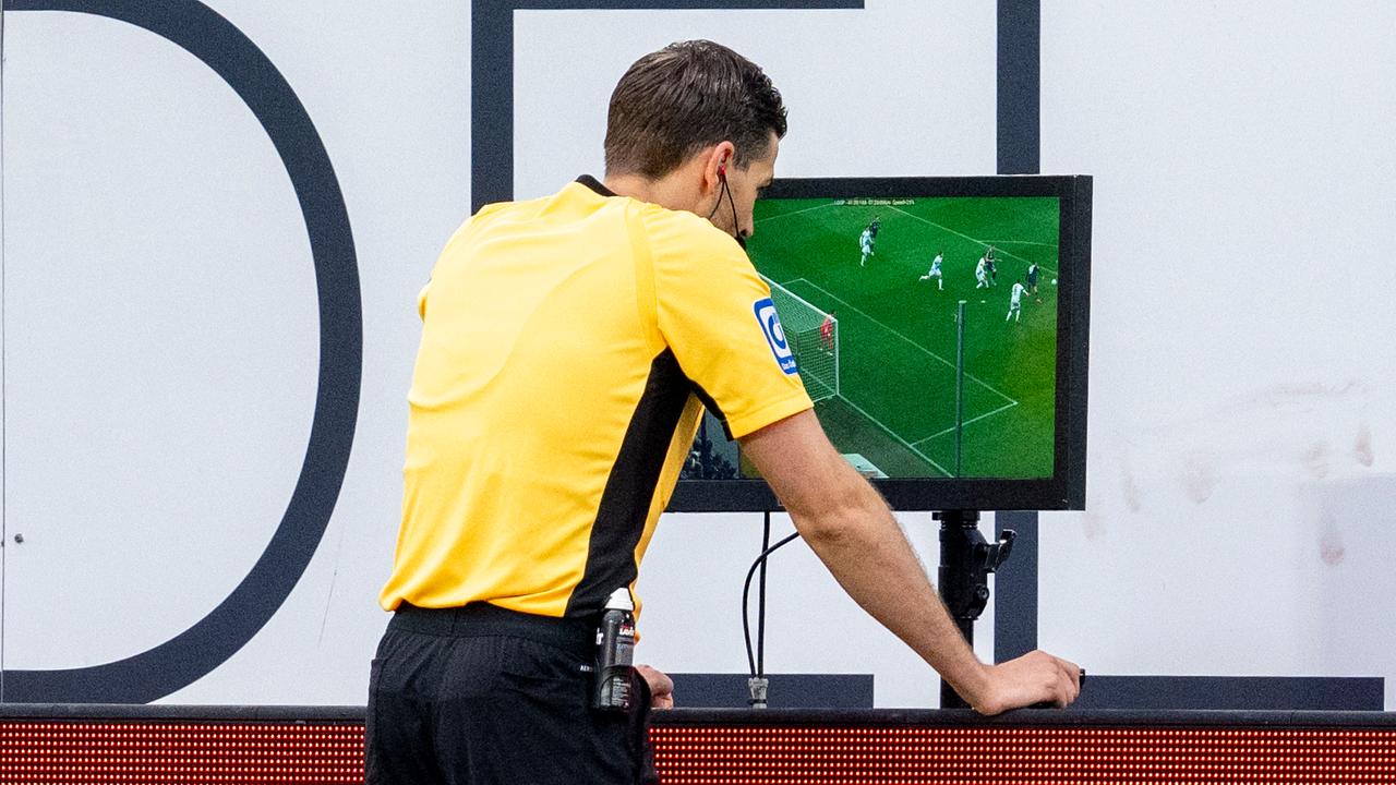 Schiedsrichter Max Burda prüft per Video-Assistent (VAR) die Szene vor dem Strafstoß.