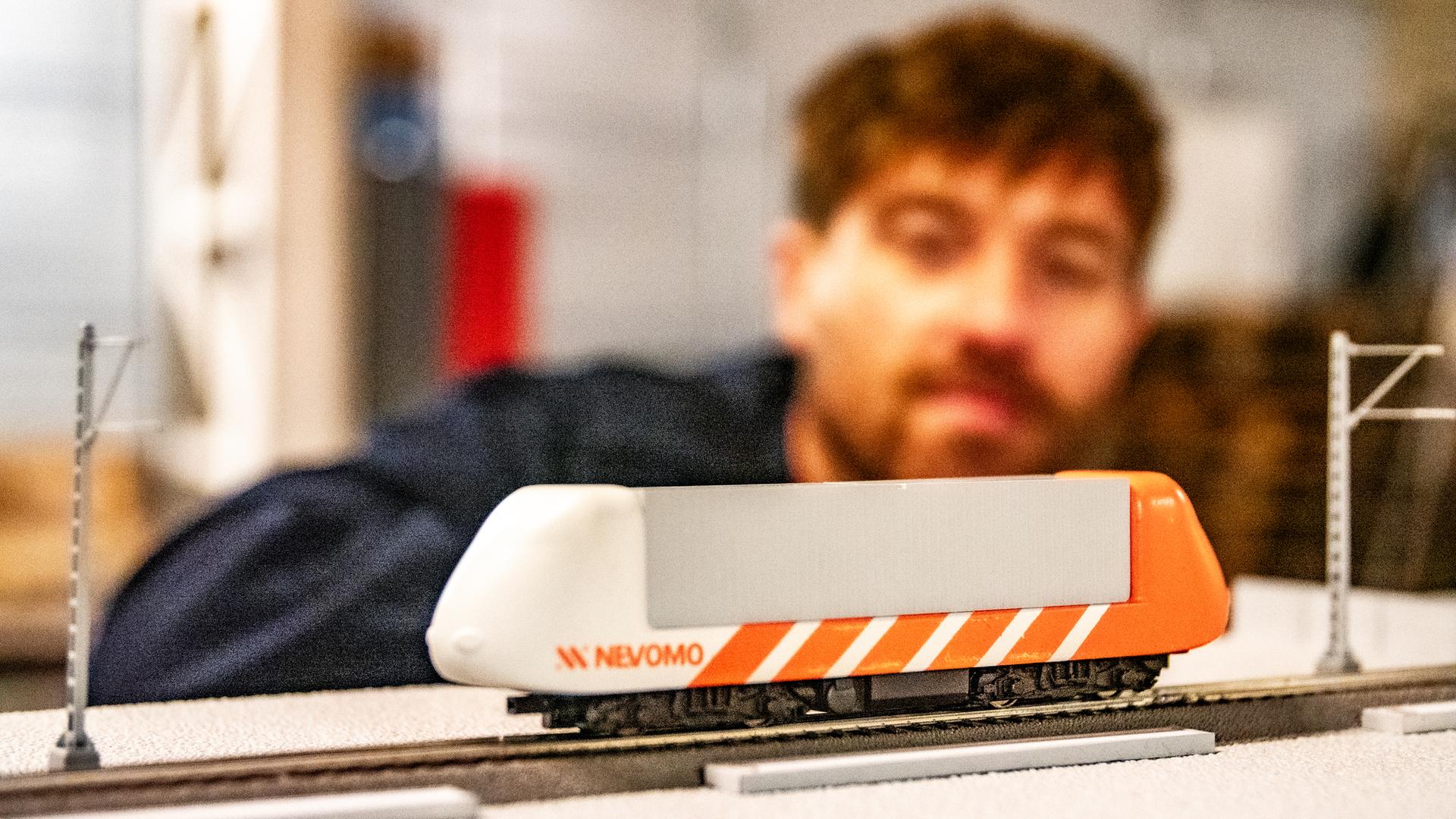 plan-b-Host Frederik Fleig schaut sich ein Modell eines Nevomo-Pods an.