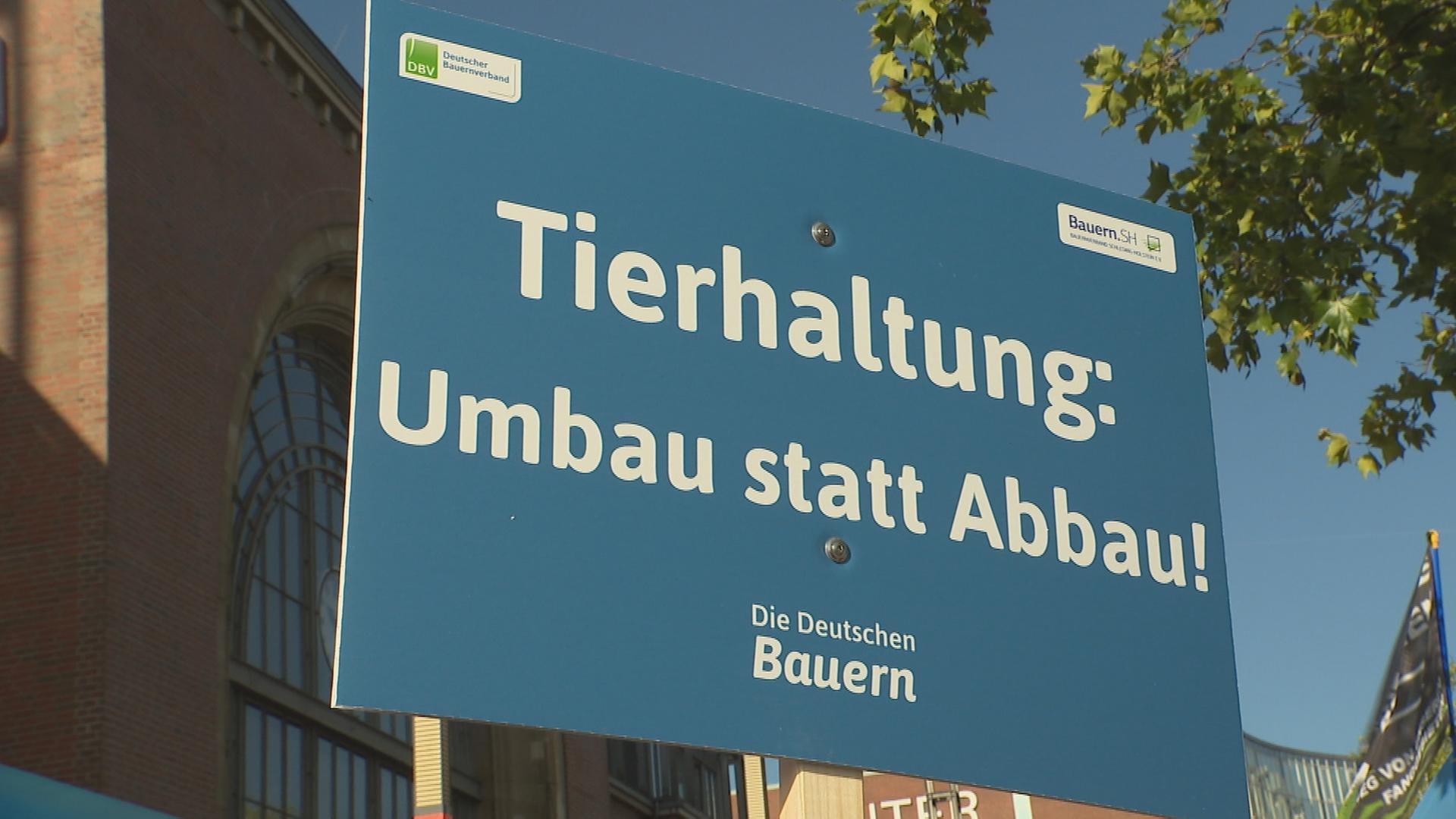 Auf dem Bild ist ein Schild zur Demonstration für Tierhaltung zu sehen.