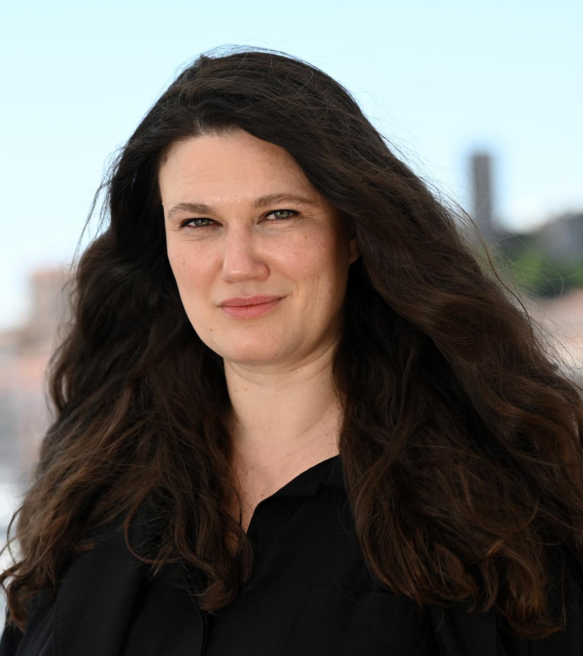 Mascha Schilinski, deutsche Regisseurin und Drehbuchautorin, lächelt bei einer Presseveranstaltung für ihren Film «In die Sonne schauen» in die Kamera.