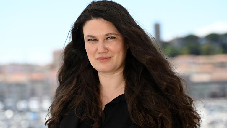 Mascha Schilinski, deutsche Regisseurin und Drehbuchautorin, lächelt bei einer Presseveranstaltung für ihren Film «In die Sonne schauen» in die Kamera.