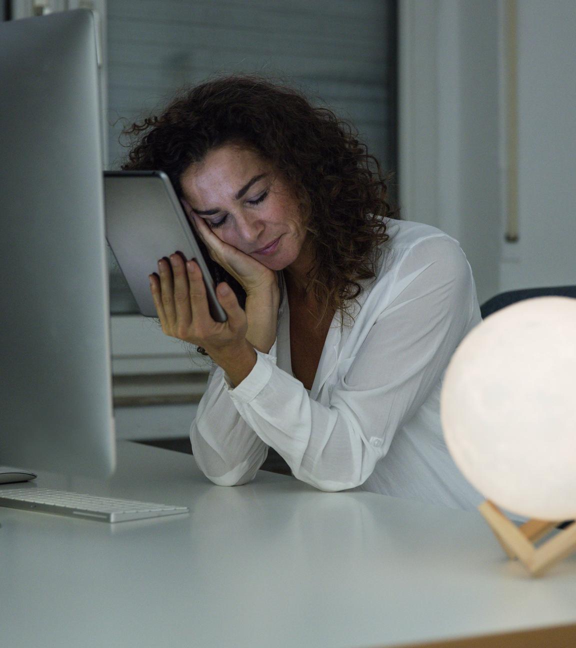Frau schläft am Arbeitsplatz