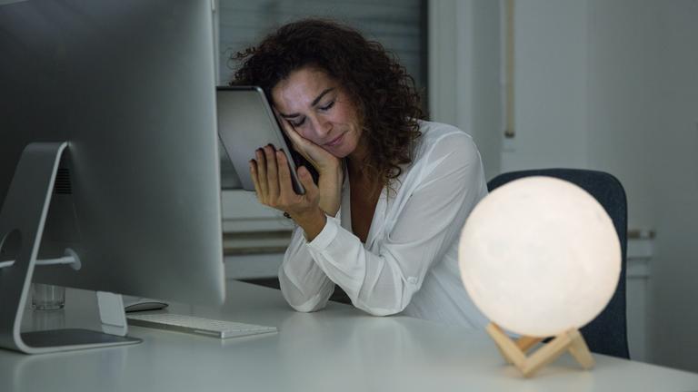 Frau schläft am Arbeitsplatz