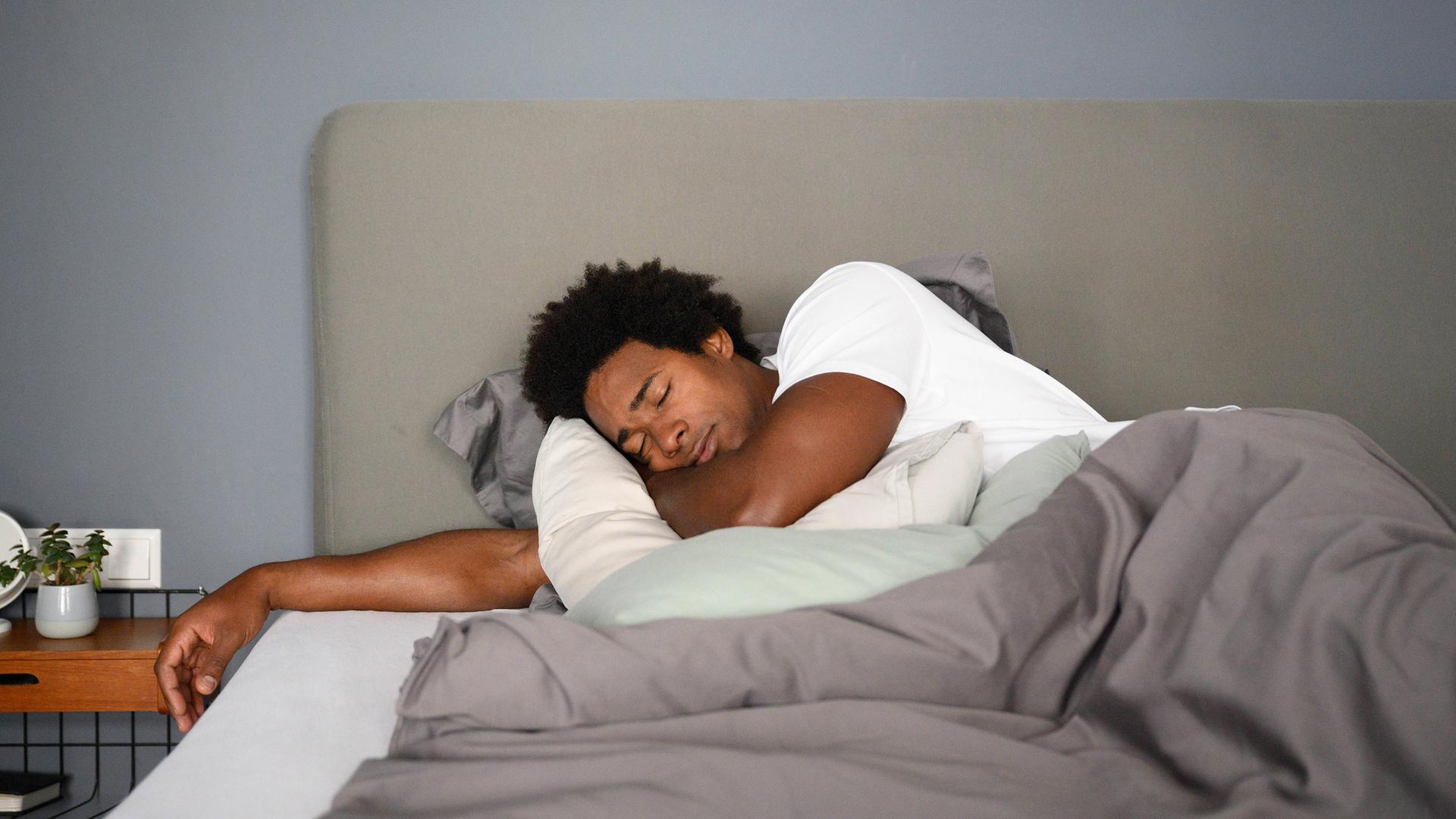 Mann schläft zu Hause im Bett