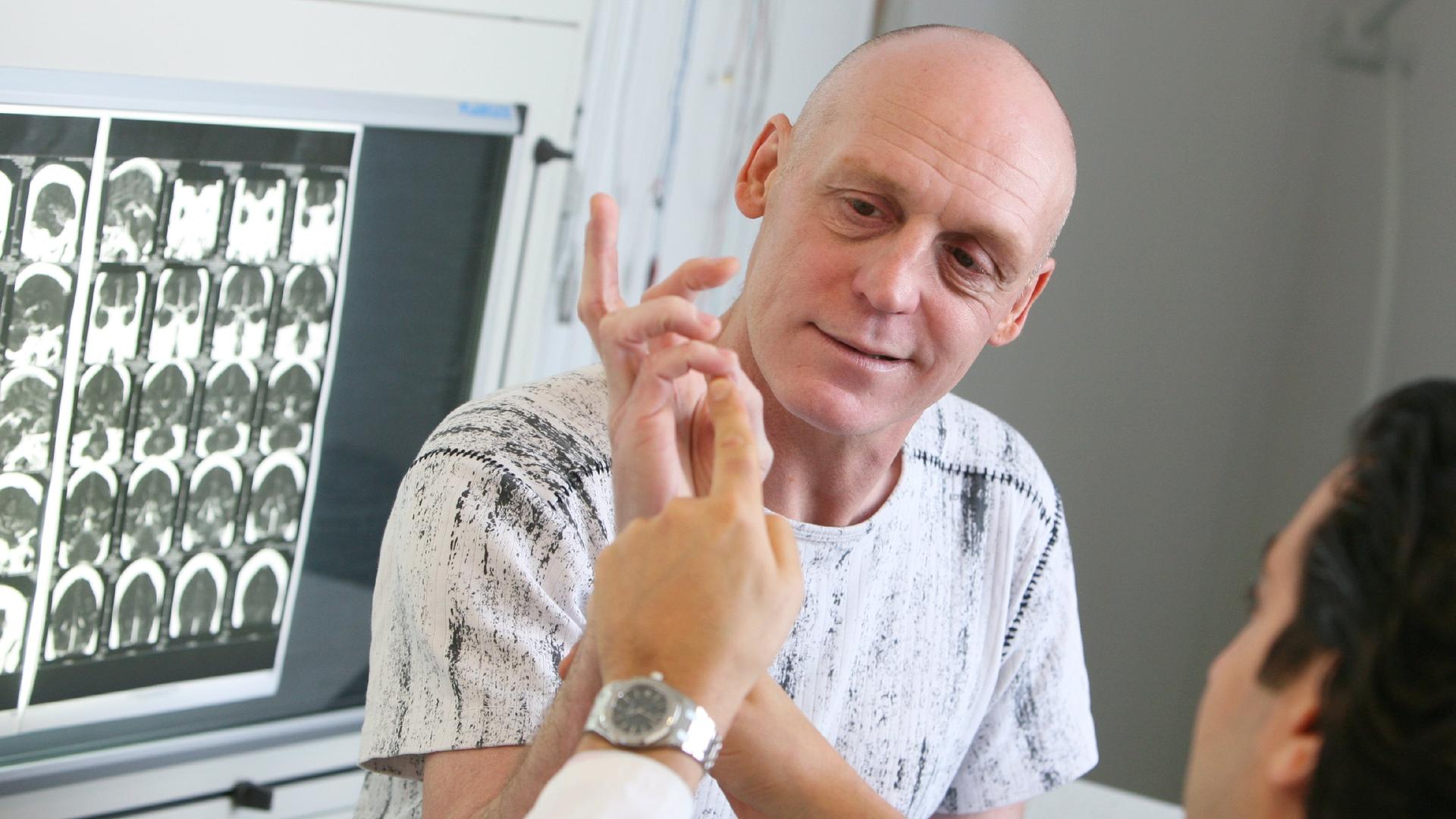 Ein Neurochirurg überprüft die Motorik der Hände bei einem Schlaganfall-Patient.