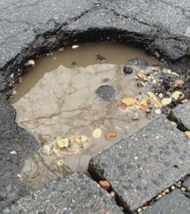 Schlagloch, gefüllt mit Wasser