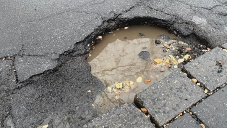 Schlagloch, gefüllt mit Wasser