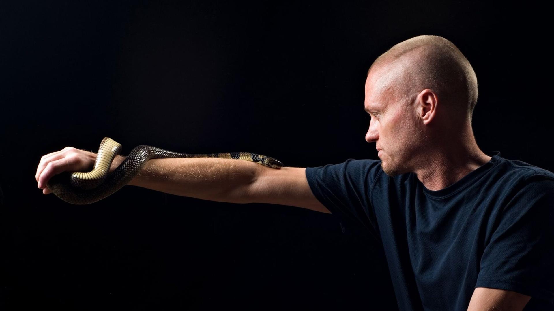 Der von Schlangen begeisterte US-Amerikaner Tim Friede trägt eine Wasserkobra auf dem Arm