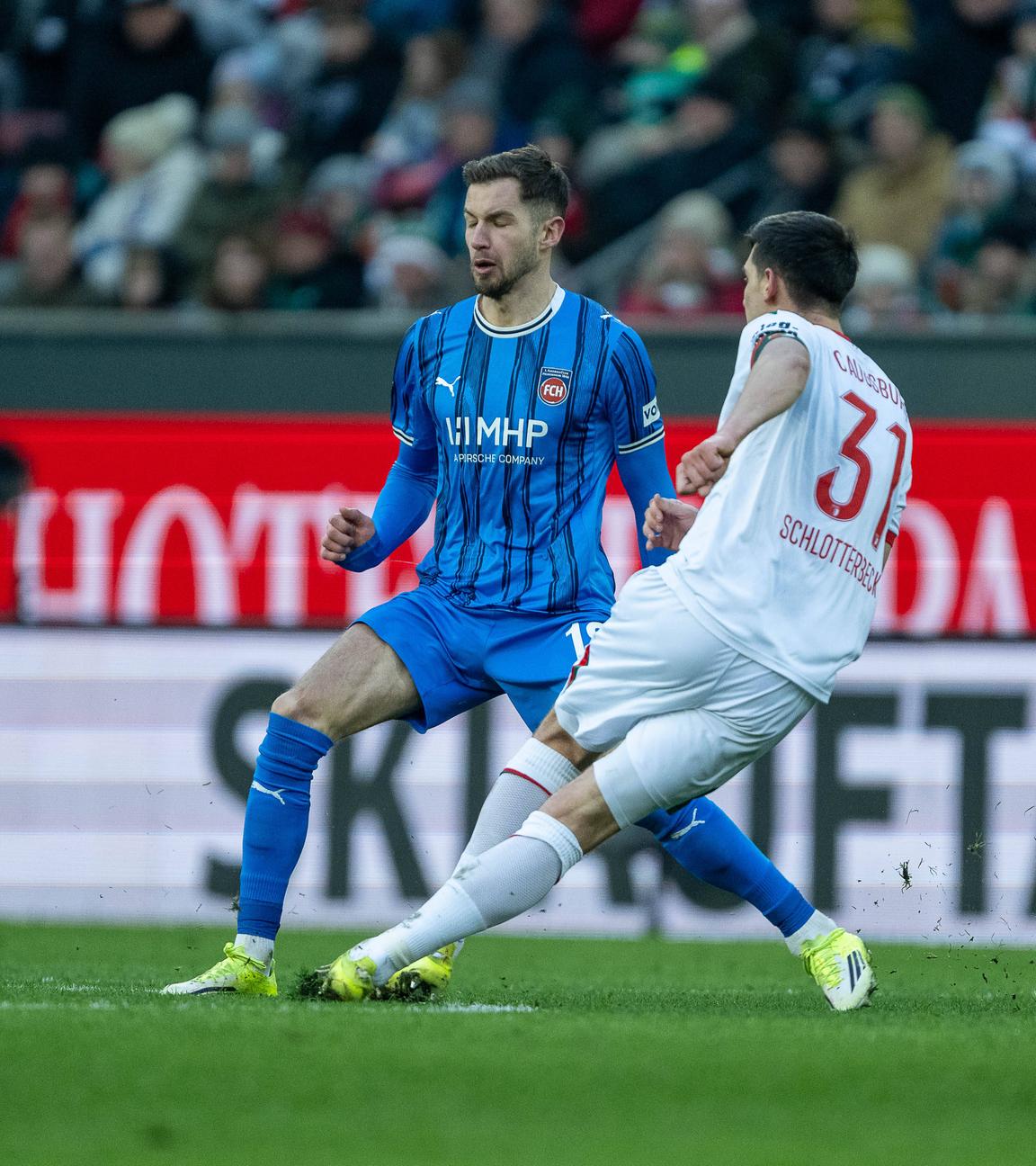 Augsburgs Innenverteidiger Keven Schlotterbeck und Heidenheims Mittelstürmer Marvin Pieringer befinden sich beide im Zweikampf um den Ball