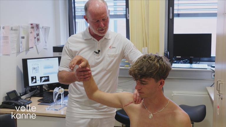 Ein junger Patient ist mit Schulter-Problemen beim Arzt