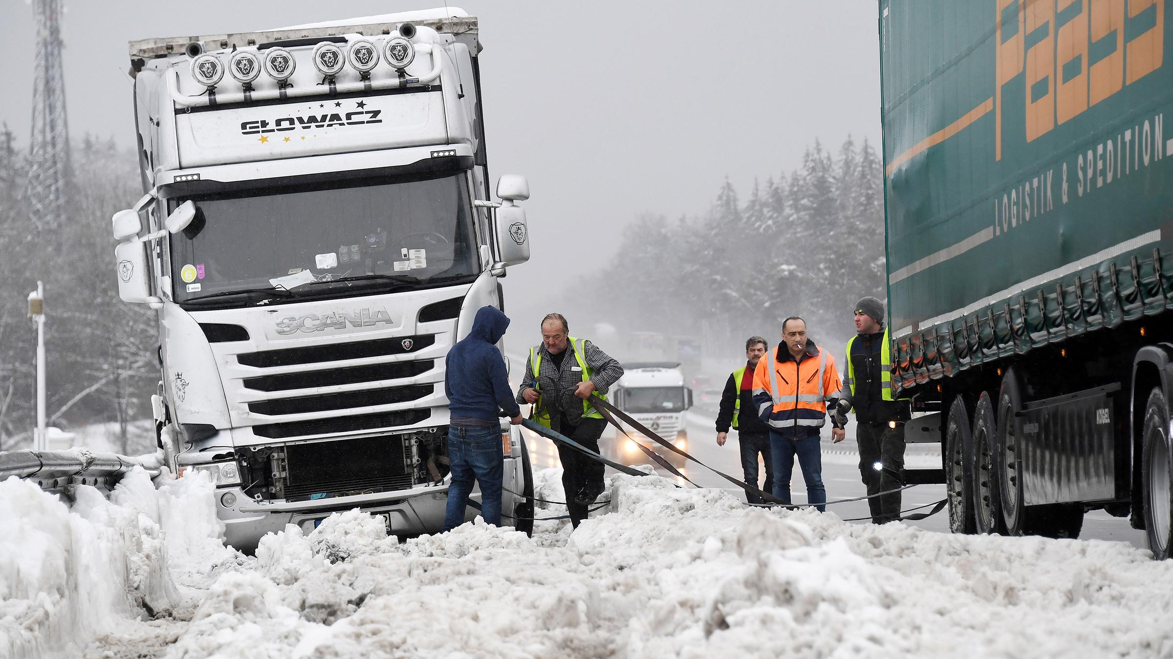 Lkw-Fahrer versuchen auf der A8 bei Holzkirchen ihre feststeckenden Fahrzeuge zu befreien.