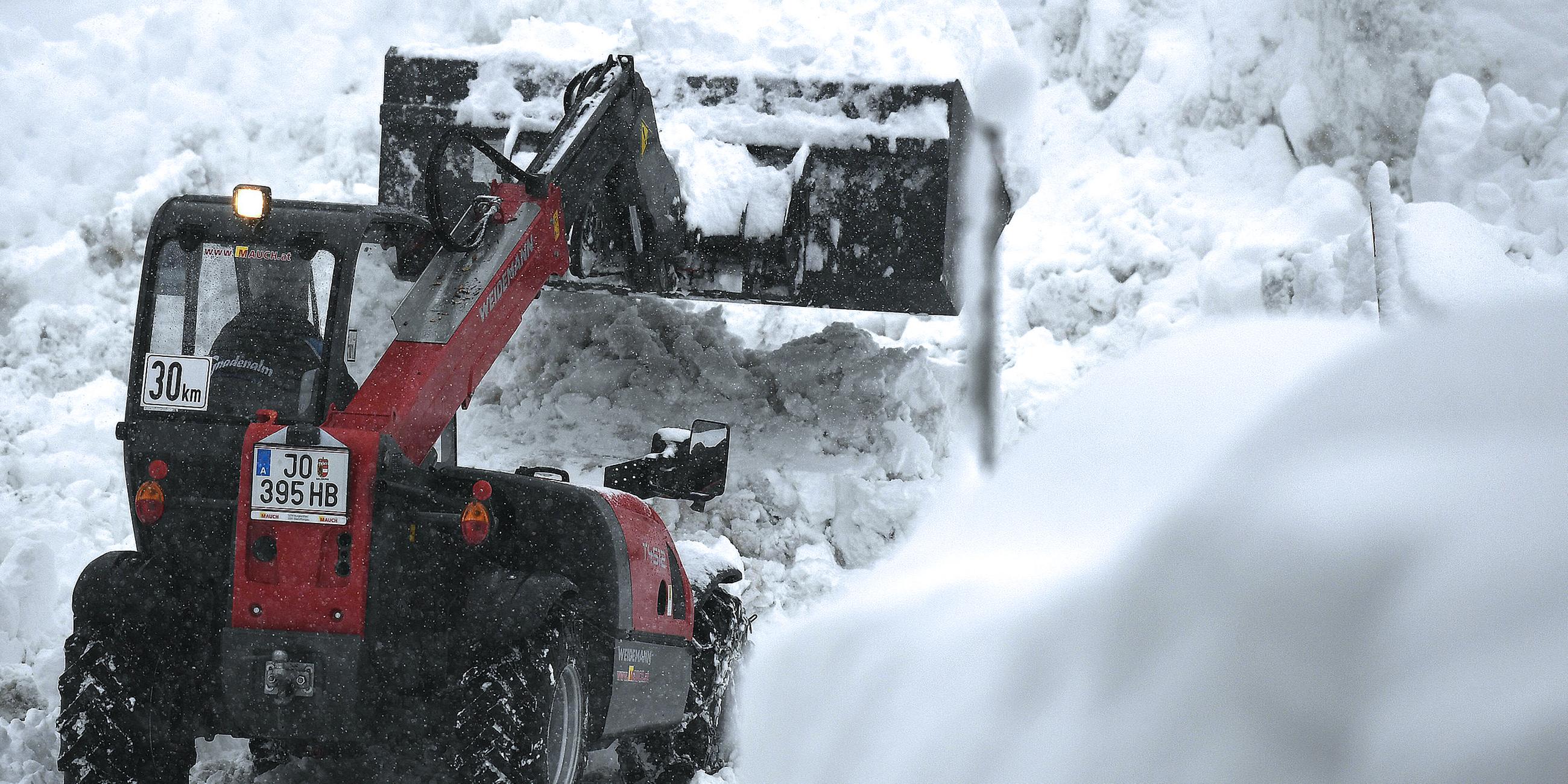 Ein Bagger befreit eine Straße vom Schnee.