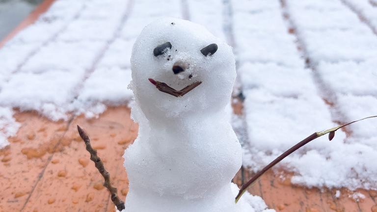 Ein kleiner Schneemann auf einem Biertisch. 