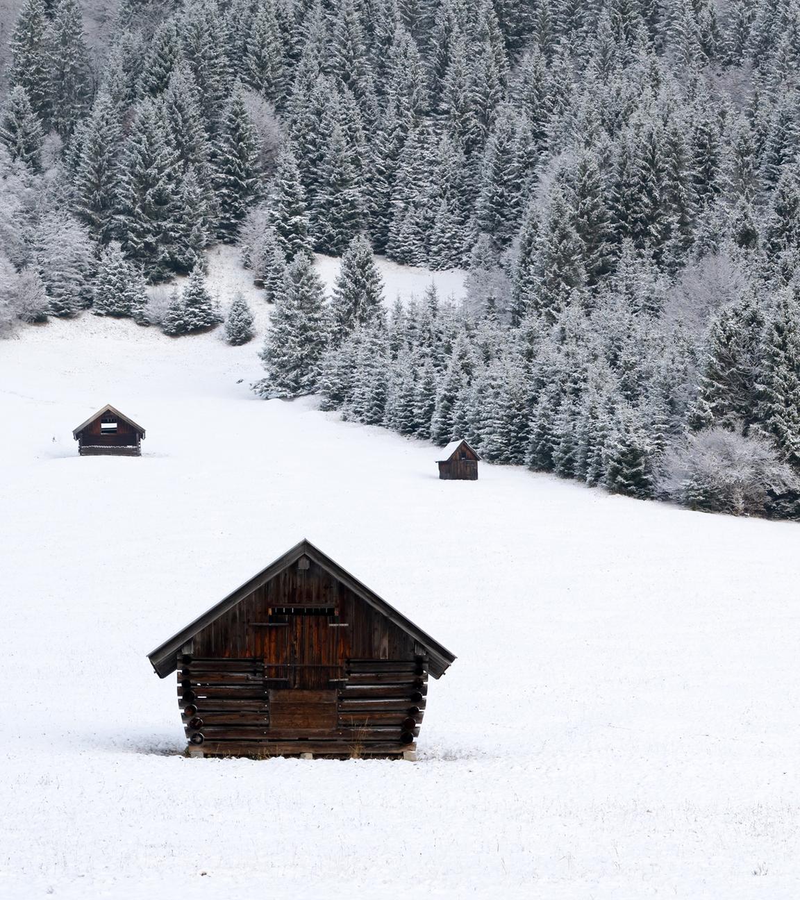 Heuschober stehen auf einer schneebedeckten Wiese (Bayern), aufgenommen am 18.11.2025