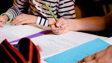 Schüler schreiben in ihre Schulhefte