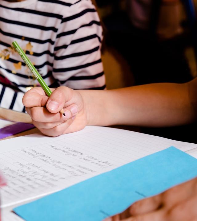 Schüler schreiben in ihre Schulhefte