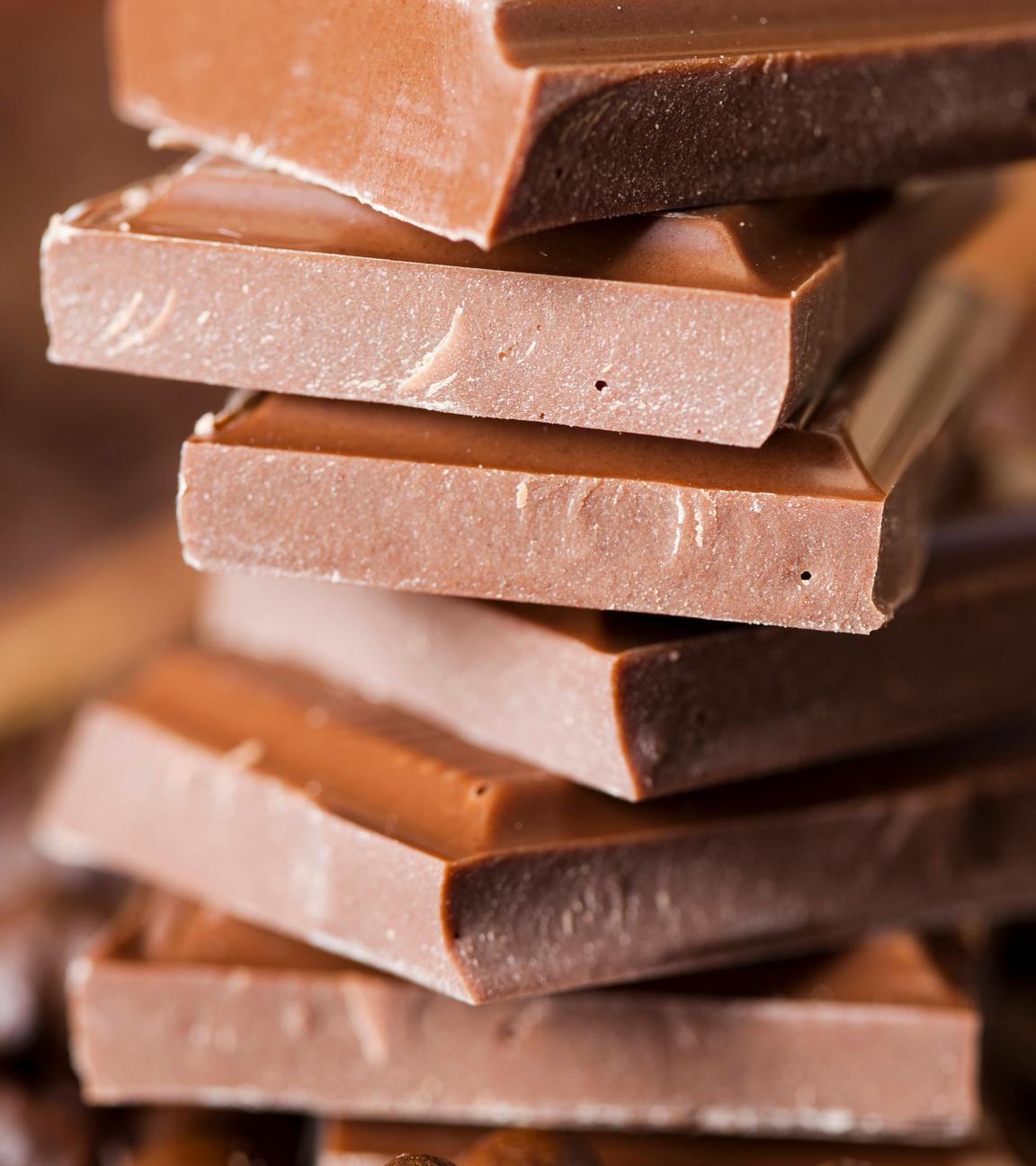 Mehrere Stücke Milchschokolade sind übereinander gestapelt.