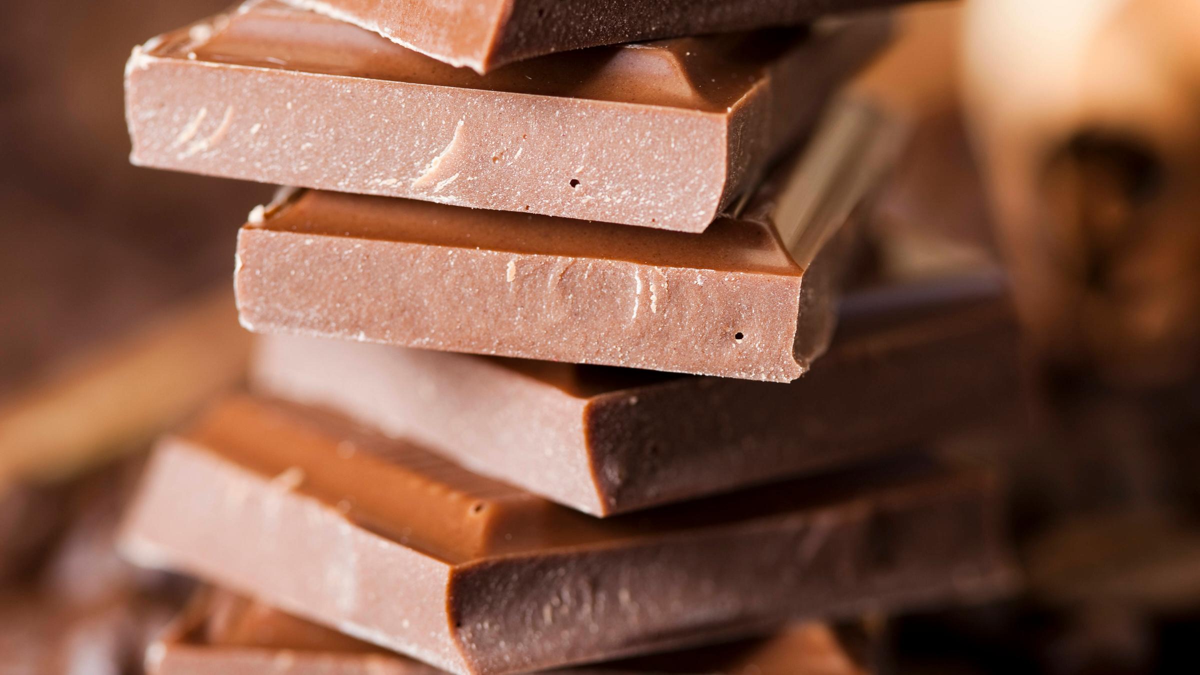 Mehrere Stücke Milchschokolade sind übereinander gestapelt.