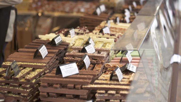 Zahlreiche Tafeln Schokolade in verschiedenen Ausführungen in einer Auslage.