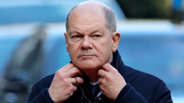 Bundeskanzler Olaf Scholz rückt seinen Kragen zurecht, als er zu einem EU-Gipfel im Egmont-Palast in Brüssel ankommt