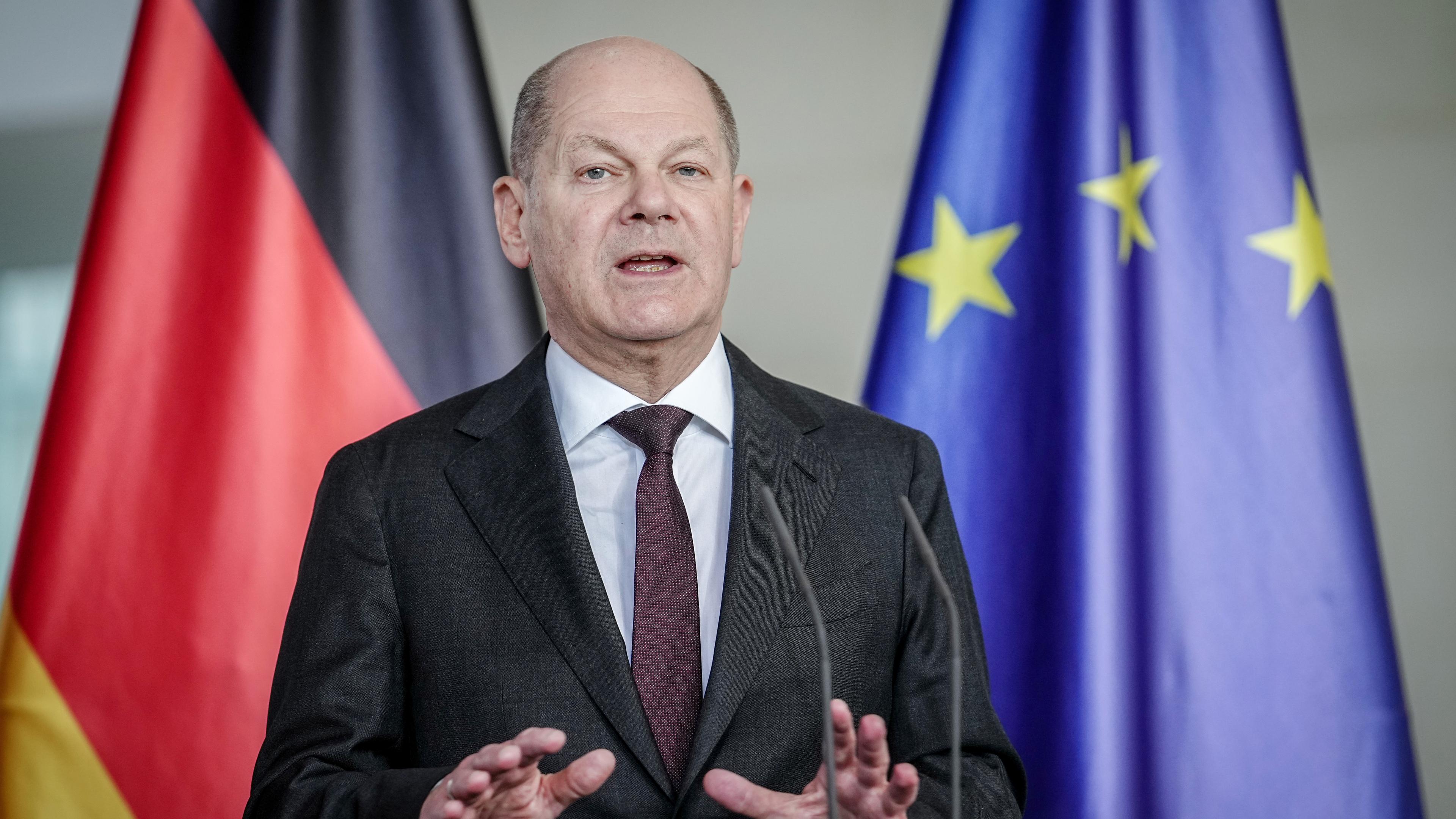 Bundeskanzler Scholz gestikuliert leicht während er spricht.