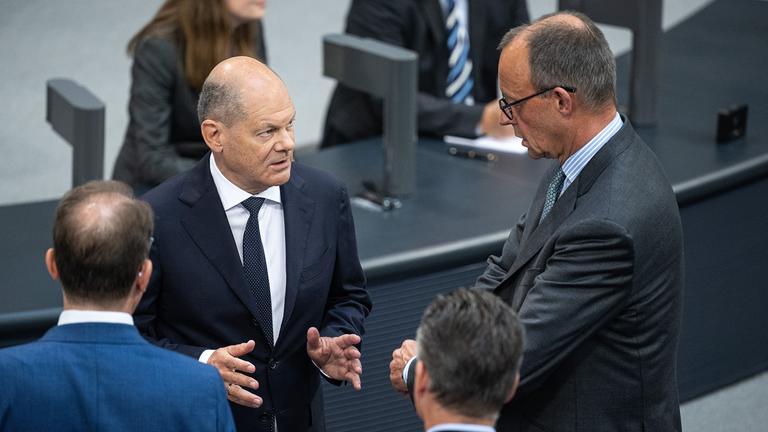 Olaf Scholz im Gespräch mit Friedrich Merz