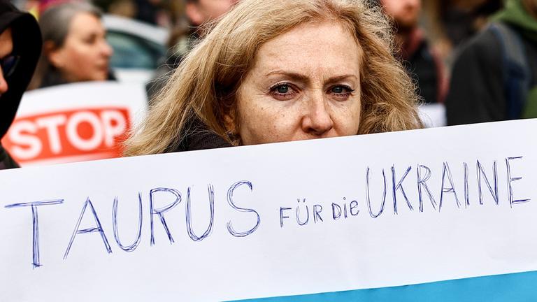 Eine Frau hält auf einer Antikriegsdemonstration in Berlin ein Plakat mit der Aufschrift "Taurus für die Ukraine".